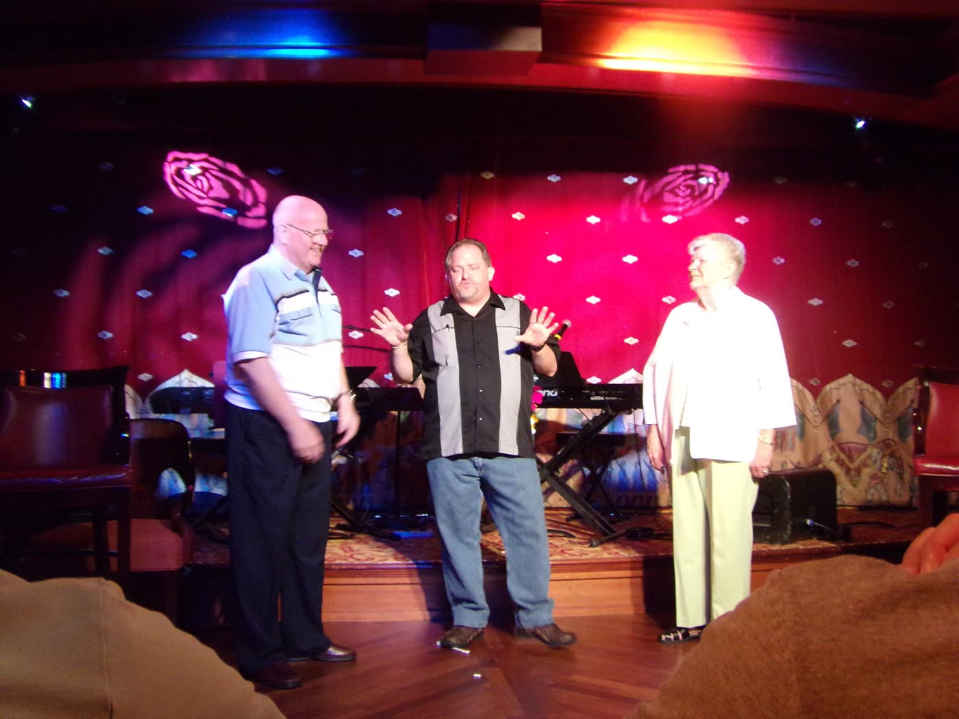Carroll Baker performing on stage with two volunteers at the Buckeye Cruise for Cancer